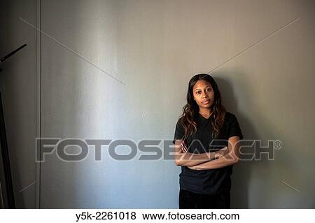 Tilburg, Netherlands. Studio shot of dark skinned woman from African decent standing against a grey, concrete wall. View Large Photo Image Stock Photo - Tilburg, Netherlands. Studio shot of dark skinned woman from African decent standing against a grey, concrete wall.. Fotosearch