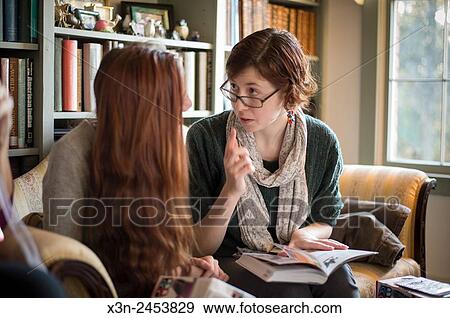 Two young women sitting on couch in living room in Fallston, Maryland, USA. View Large Photo Image Stock Photo - Two young women sitting on couch in living room in Fallston, Maryland, USA.. Fotosearch
