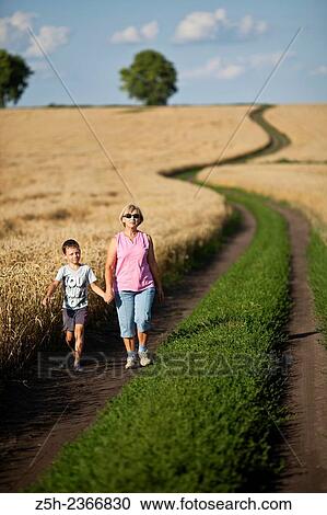 Stock Image - Wheat fields of the Belgorod region. Grandmother with grandson in a wheat field.. Fotosearch
