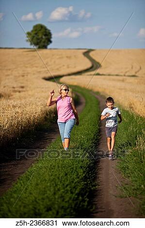 Stock Image - Wheat fields of the Belgorod region. Grandmother with grandson in a wheat field.. Fotosearch