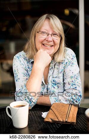 Stock Photograph - Woman, 60, at a coffee shop.. Fotosearch