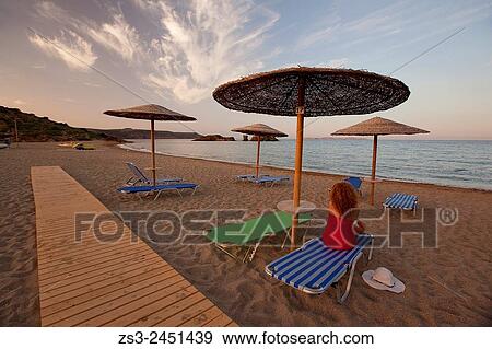 Woman and thatched umbrellas at the sandy Vai beach at sunset, Lasithi Region, Crete, Greek Islands, Greece, Europe. View Large Photo Image Stock Photo - Woman and thatched umbrellas at the sandy Vai beach at sunset, Lasithi Region, Crete, Greek Islands, Greece, Europe.. Fotosearch