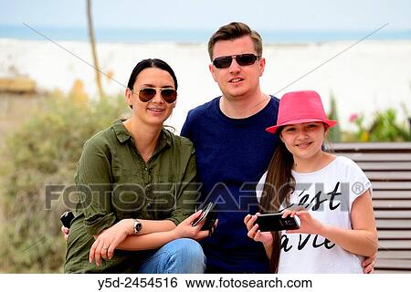 Stock Photograph - young family on summer vacation, in the background beach in Armacao de Pera, Silves, Algarve, Portugal, Europe.. Fotosearch