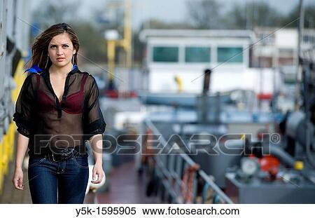 Young, fashionable woman from Afghanistan, living in asylum in the Netherlands, posing near the docks of Rotterdam harbor, wandering alongside the dock where a barge is moored. View Large Photo Image Stock Photography - Young, fashionable woman from Afghanistan, living in asylum in the Netherlands, posing near the docks of Rotterdam harbor, wandering alongside the dock where a barge is moored.. Fotosearch