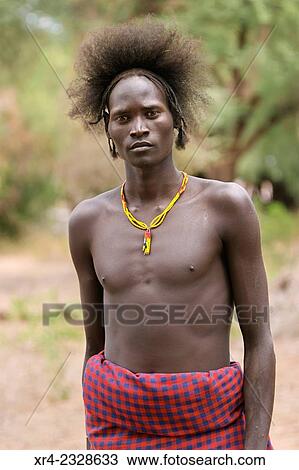 Stock Image - Young man to the tribe Geleb waiting to cross the Omo River, Omorate. Ethiopia. Fotosearch