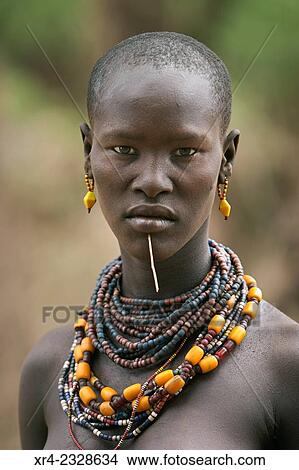 Young woman to the tribe Geleb waiting to cross the Omo River, Omorate, Ethiopia View Large Photo Image Picture - Young woman to the tribe Geleb waiting to cross the Omo River, Omorate, Ethiopia. Fotosearch