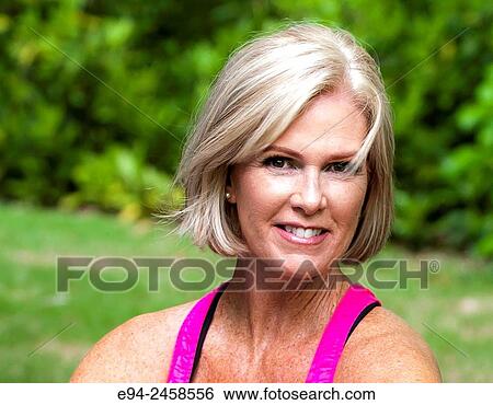 56 year old blond woman smiling at the camera, outdoors. View Large Photo Image Stock Photograph - 56 year old blond woman smiling at the camera, outdoors.. Fotosearch