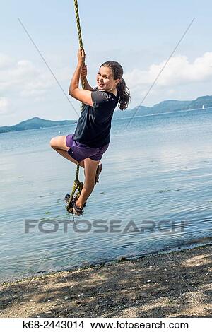 a girl, 12, swings on a rope on Saturna Island, BC, Canada. View Large Photo Image Picture - a girl, 12, swings on a rope on Saturna Island, BC, Canada.. Fotosearch