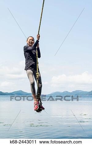 a girl, 12, swings on a rope on Saturna Island, BC, Canada. View Large Photo Image Stock Image - a girl, 12, swings on a rope on Saturna Island, BC, Canada.. Fotosearch