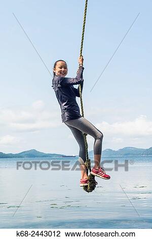 a girl, 12, swings on a rope on Saturna Island, BC, Canada. View Large Photo Image Stock Image - a girl, 12, swings on a rope on Saturna Island, BC, Canada.. Fotosearch