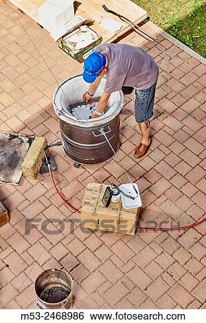 A person placing ceramic objects inside a gas firing kiln, ready for the heating process. View Large Photo Image Stock Photograph - A person placing ceramic objects inside a gas firing kiln, ready for the heating process.. Fotosearch