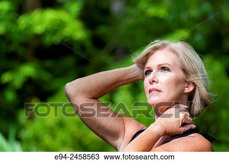 A portrait of a 56 year old blond woman looking away from the camera, outdoors. View Large Photo Image Stock Image - A portrait of a 56 year old blond woman looking away from the camera, outdoors.. Fotosearch