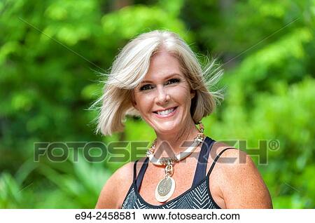 A portrait of a 56 year old blond woman smiling directly at the camera, outdoors.. View Large Photo Image Stock Image - A portrait of a 56 year old blond woman smiling directly at the camera, outdoors... Fotosearch