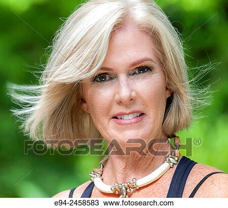 A portrait of a 56 year old blond woman smiling directly at the camera, outdoors.. View Large Photo Image Stock Image - A portrait of a 56 year old blond woman smiling directly at the camera, outdoors... Fotosearch