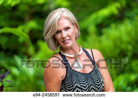 A portrait of a 56 year old blond woman smiling directly at the camera, outdoors. View Large Photo Image Stock Image - A portrait of a 56 year old blond woman smiling directly at the camera, outdoors.. Fotosearch