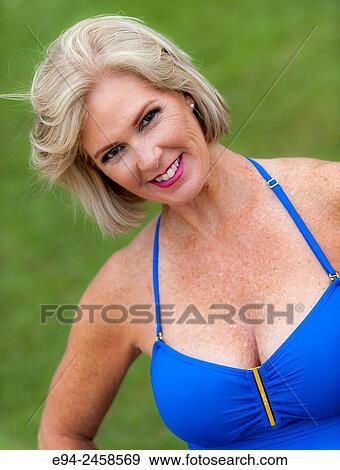 A portrait of a 56 year old blond woman smiling directly at the camera, outdoors. View Large Photo Image Stock Photo - A portrait of a 56 year old blond woman smiling directly at the camera, outdoors.. Fotosearch