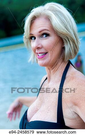 A portrait of a 56 year old blond woman wearing a swim suit and smiling directly at the camera, outdoors.. View Large Photo Image Stock Photo - A portrait of a 56 year old blond woman wearing a swim suit and smiling directly at the camera, outdoors... Fotosearch