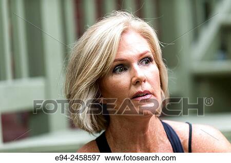 A portrait of a 56 year old blond woman looking away from the camera, outdoors. View Large Photo Image Stock Photo - A portrait of a 56 year old blond woman looking away from the camera, outdoors.. Fotosearch