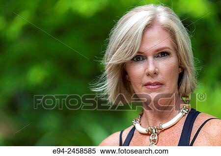 A portrait of a 56 year old blond woman looking directly at the camera, outdoors.. View Large Photo Image Stock Photography - A portrait of a 56 year old blond woman looking directly at the camera, outdoors... Fotosearch