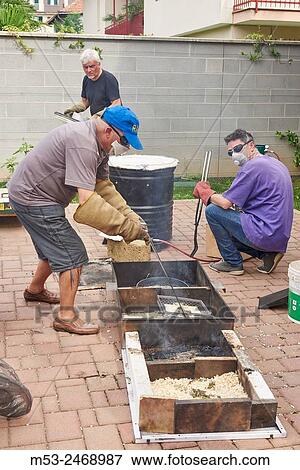 Stock Photo - A raku master handling a piece of hot ceramic just removed from oven.. Fotosearch