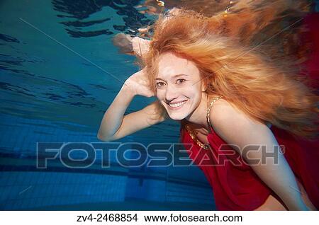 A young woman under water in a swimming bath. View Large Photo Image Picture - A young woman under water in a swimming bath.. Fotosearch