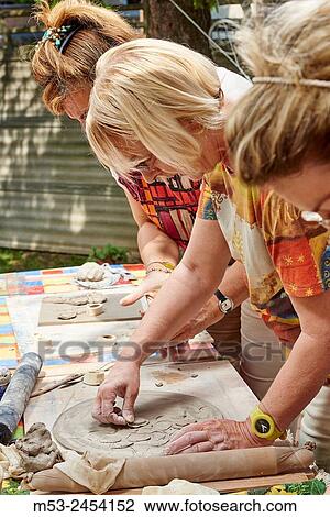 Stock Image - Amateur artists while modeling clay to obtain raku ceramics.. Fotosearch