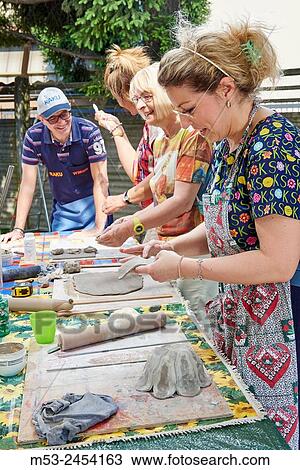Amateur artists while modeling clay to obtain raku ceramics. View Large Photo Image Stock Image - Amateur artists while modeling clay to obtain raku ceramics.. Fotosearch