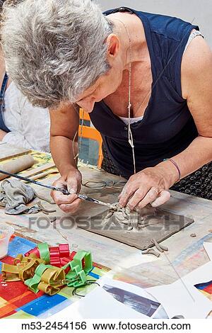 Amateur artists while modeling clay to obtain raku ceramics. View Large Photo Image Stock Photograph - Amateur artists while modeling clay to obtain raku ceramics.. Fotosearch