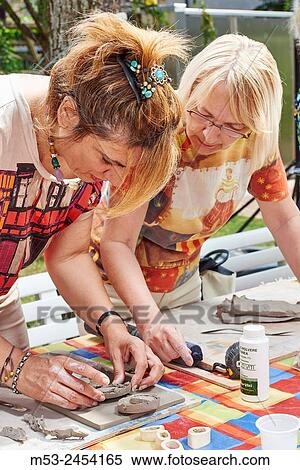 Stock Photography - Amateur artists while modeling clay to obtain raku ceramics.. Fotosearch