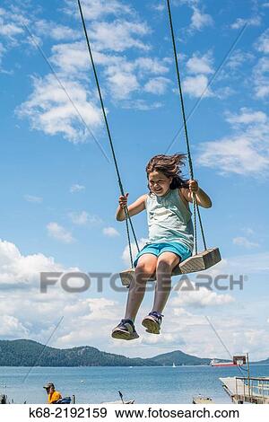 An 11 year old girl on a swing on Saturna Island, Gulf Islands, British Columbia, Canada. View Large Photo Image Stock Photo - An 11 year old girl on a swing on Saturna Island, Gulf Islands, British Columbia, Canada.. Fotosearch