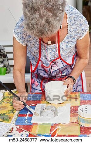 An amateur artist apply raku glaze on ceramic object. View Large Photo Image Stock Photo - An amateur artist apply raku glaze on ceramic object.. Fotosearch