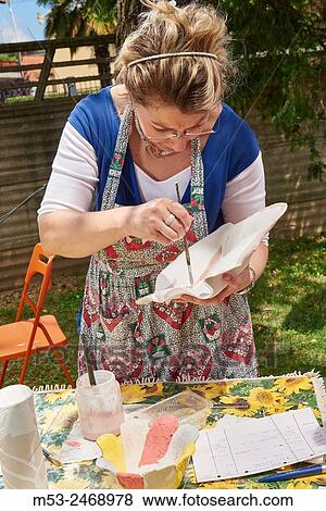 An amateur artist apply raku glaze on ceramic object. View Large Photo Image Stock Photo - An amateur artist apply raku glaze on ceramic object.. Fotosearch