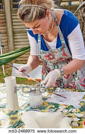 An amateur artist apply raku glaze on ceramic object. View Large Photo Image Stock Photography - An amateur artist apply raku glaze on ceramic object.. Fotosearch