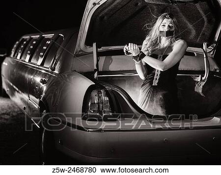 Attractive blond girl inside the trunk of the limousine, hands tied and mouth taped, intentional noise added, tinted black and white image. View Large Photo Image Stock Image - Attractive blond girl inside the trunk of the limousine, hands tied and mouth taped, intentional noise added, tinted black and white image.. Fotosearch