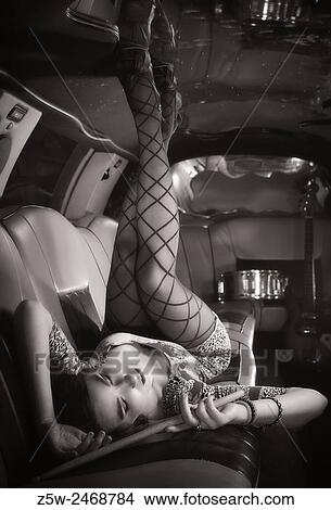 Attractive girl posing inside the limousine, drumsticks, tinted black and white image. View Large Photo Image Picture - Attractive girl posing inside the limousine, drumsticks, tinted black and white image.. Fotosearch