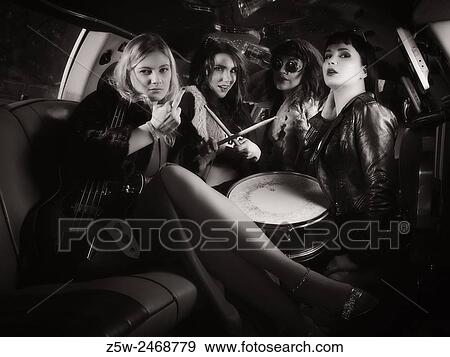 Stock Photo - Attractive girls partying together, inside the limousine, music instruments, tinted black and white image.. Fotosearch