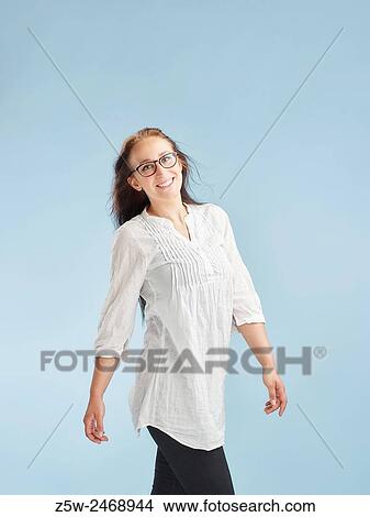 Picture - Attractive young woman posing in studio, light blue background - healthy lifestyle theme.. Fotosearch