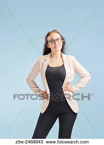 Stock Image - Attractive young woman posing in studio, light blue background - healthy lifestyle theme.. Fotosearch