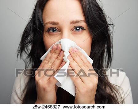 Close up, young woman blowing her nose, gray background. View Large Photo Image Stock Photo - Close up, young woman blowing her nose, gray background.. Fotosearch