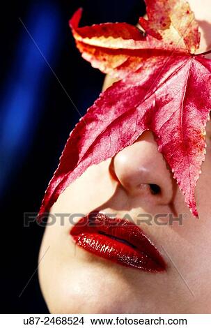 Closeup of Young Female headshot with colorful leaves next to her face.. View Large Photo Image Picture - Closeup of Young Female headshot with colorful leaves next to her face... Fotosearch