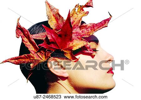 Stock Image - Closeup of Young Female headshot with colorful leaves next to her face... Fotosearch