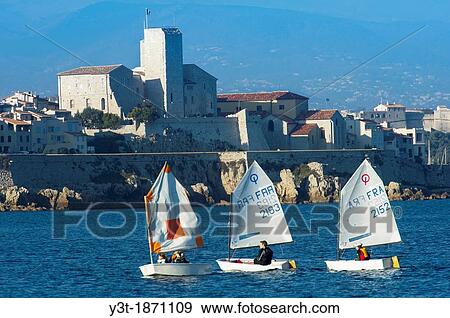 Stock Photo - Europe, France, Alpes-Maritimes, Antibes. Boat in front of ramparts on the old town.. Fotosearch
