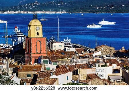 Stock Photo - Europe, France, Var, Saint-Tropez. The parochial church in the village and the Gulf of Saint-Tropez.. Fotosearch