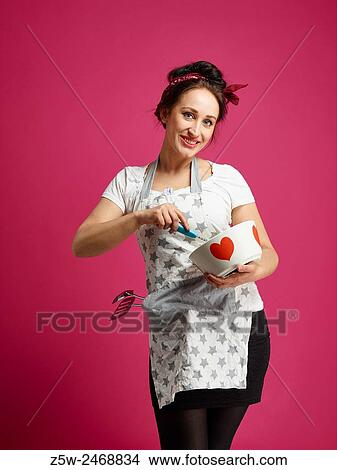 Funny housewife and kitchen utensils, pink background. View Large Photo Image Picture - Funny housewife and kitchen utensils, pink background.. Fotosearch