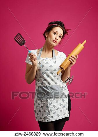Funny housewife and kitchen utensils, pink background. View Large Photo Image Stock Photo - Funny housewife and kitchen utensils, pink background.. Fotosearch