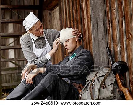 Stock Image - Historic costume theme World War II, Finnish soldier and the Lotta. Photographed in the Ragvalds museum area in Kirkkonummi, Finland.. Fotosearch