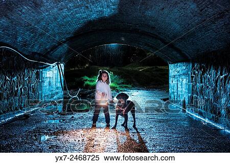 Lonely girl with her pet dog in a tunnel at night time. View Large Photo Image Stock Photography - Lonely girl with her pet dog in a tunnel at night time.. Fotosearch