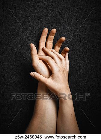 Stock Photography - Man and woman, hands connecting together, dark canvas background.. Fotosearch