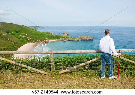 Man at the viewpoint over Torimbia beach. Niembro, Asturias, Spain. View Large Photo Image Picture - Man at the viewpoint over Torimbia beach. Niembro, Asturias, Spain.. Fotosearch
