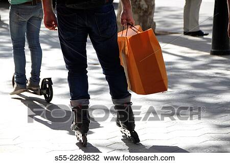 Spain, Catalonia, Barcelona, Man and woman skating along Passeig de Gracia after shopping View Large Photo Image Stock Image - Spain, Catalonia, Barcelona, Man and woman skating along Passeig de Gracia after shopping. Fotosearch